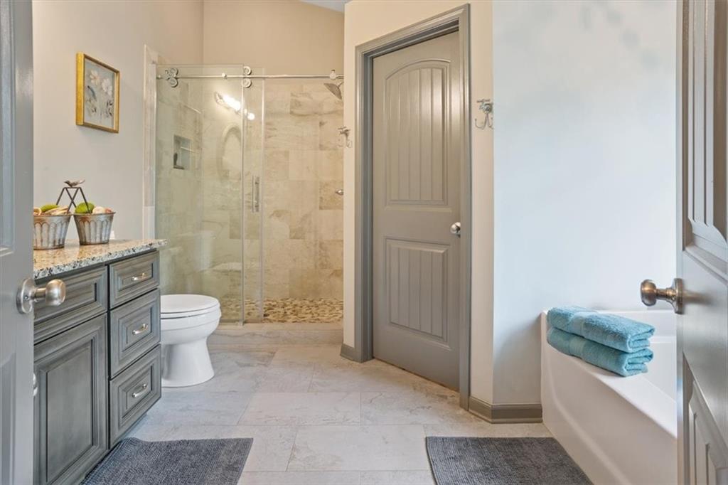 253 Zenith Trail Ellijay, GA 30540 - Photo 14 of 34 a bathroom with a granite countertop toilet a sink and shower