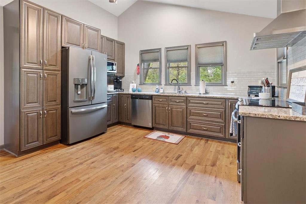 253 Zenith Trail Ellijay, GA 30540 - Photo 7 of 34 a kitchen with stainless steel appliances granite countertop a refrigerator a sink dishwasher a stove with large countertops with wooden floor