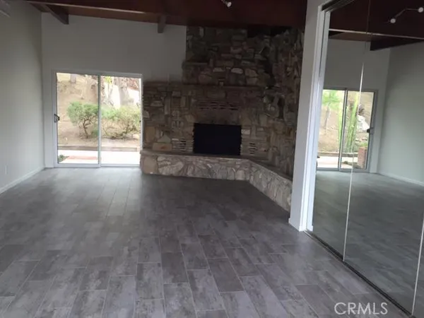 a view of empty room with wooden floor and fireplace