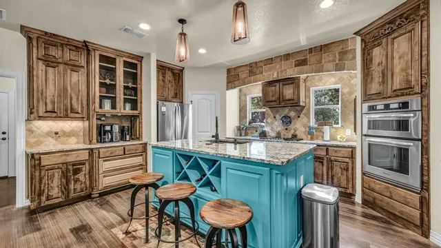 a kitchen with stainless steel appliances granite countertop a stove and cabinets
