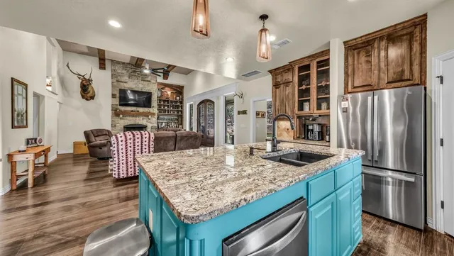 a kitchen with stainless steel appliances granite countertop furniture wooden floor and a refrigerator