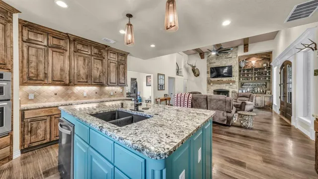 a kitchen with stainless steel appliances granite countertop a sink dishwasher and cabinets with wooden floor