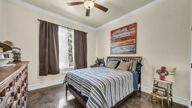 a bedroom with a bed and a dresser next to a window