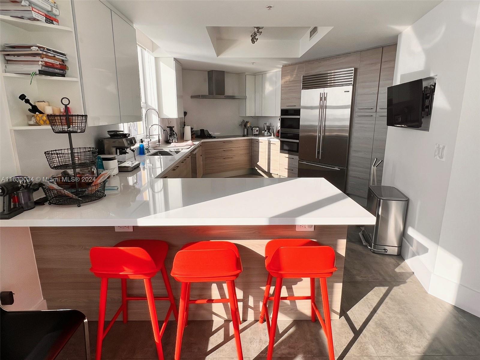 848 Brickell Key Drive, Unit 3701 Miami, FL 33131 - Photo 19 of 84 a kitchen with stainless steel appliances a dining table chairs and refrigerator