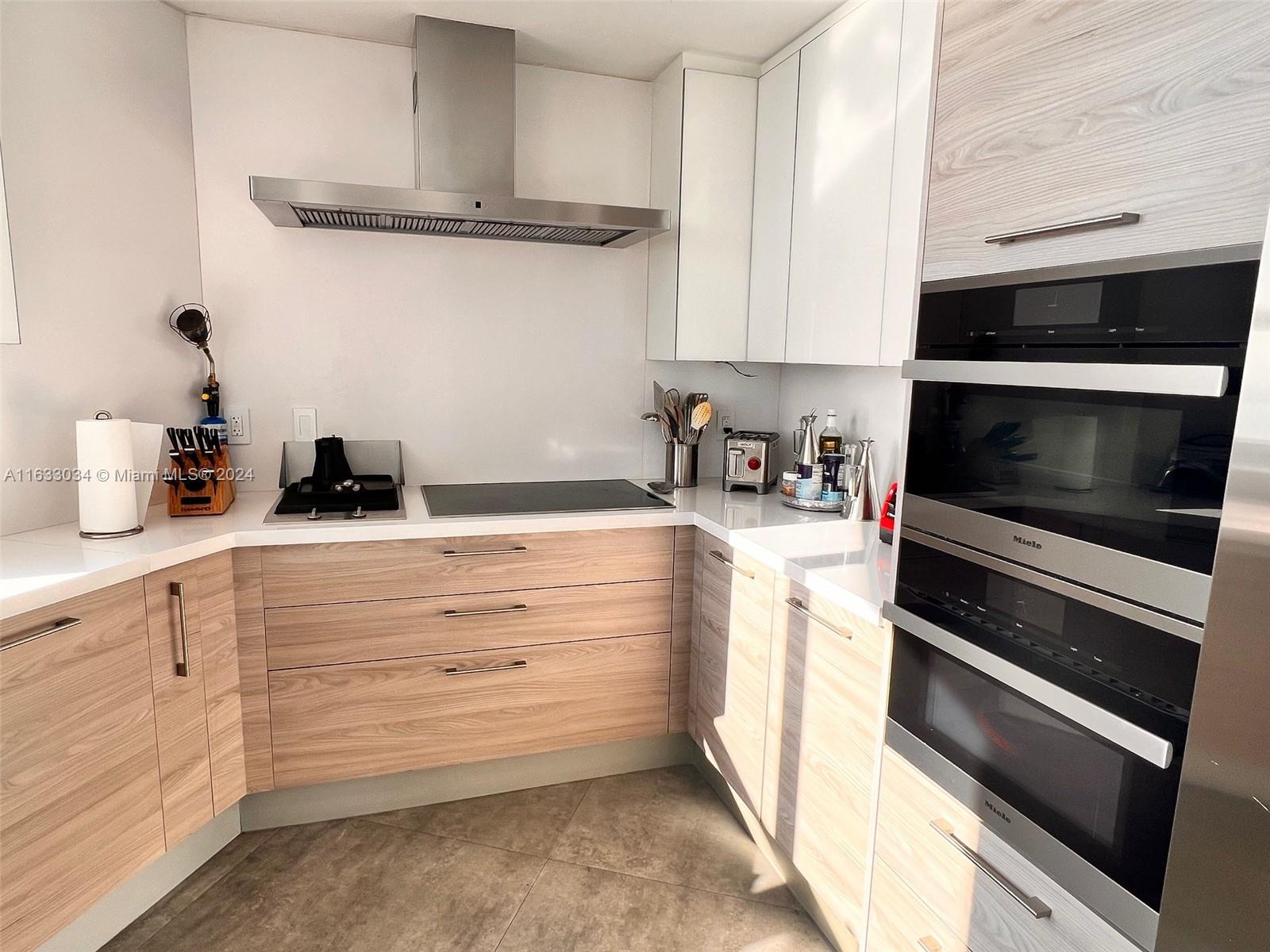 848 Brickell Key Drive, Unit 3701 Miami, FL 33131 - Photo 23 of 84 a kitchen with white cabinets and appliances