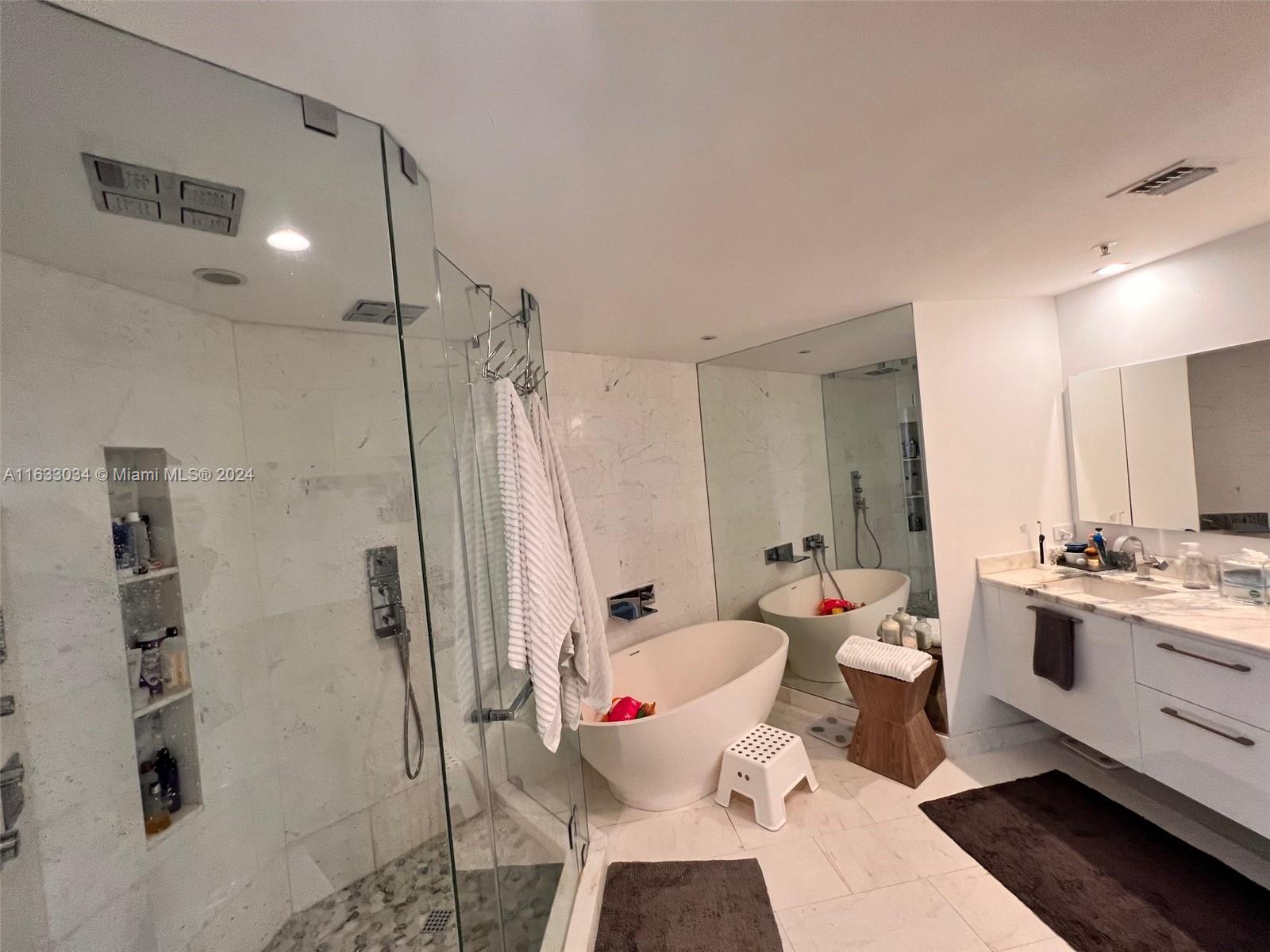 848 Brickell Key Drive, Unit 3701 Miami, FL 33131 - Photo 45 of 84 a bathroom with a sink mirror vanity and toilet
