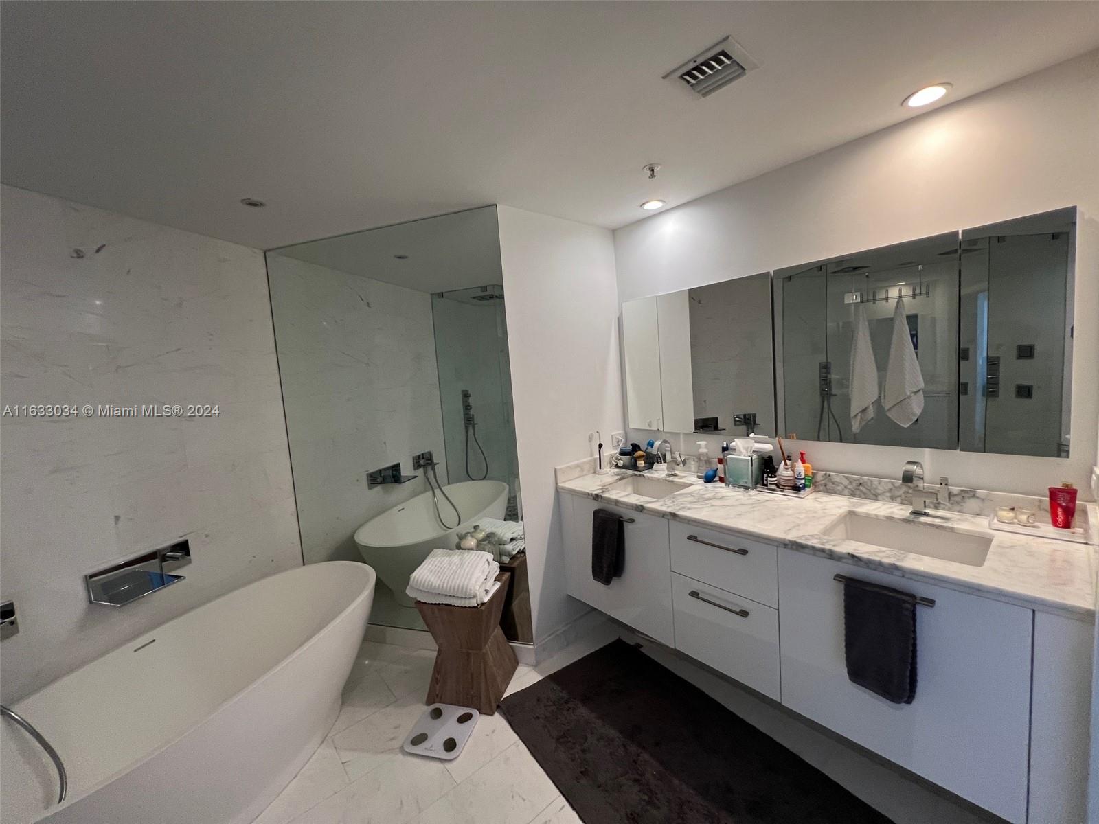 848 Brickell Key Drive, Unit 3701 Miami, FL 33131 - Photo 50 of 84 a bathroom with a double vanity sink toilet and mirror