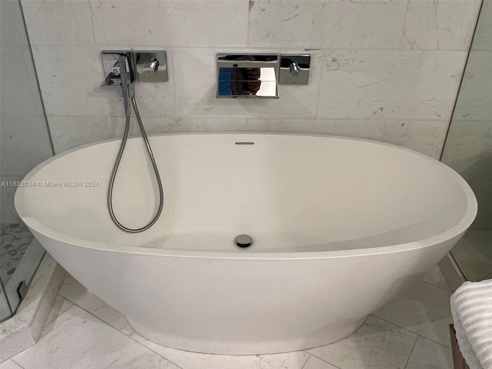 848 Brickell Key Drive, Unit 3701 Miami, FL 33131 - Photo 52 of 84 a white bath tub sitting in a bathroom