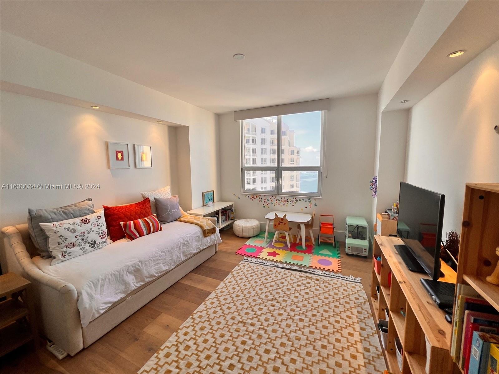 848 Brickell Key Drive, Unit 3701 Miami, FL 33131 - Photo 53 of 84 a bedroom with furniture and a flat screen tv