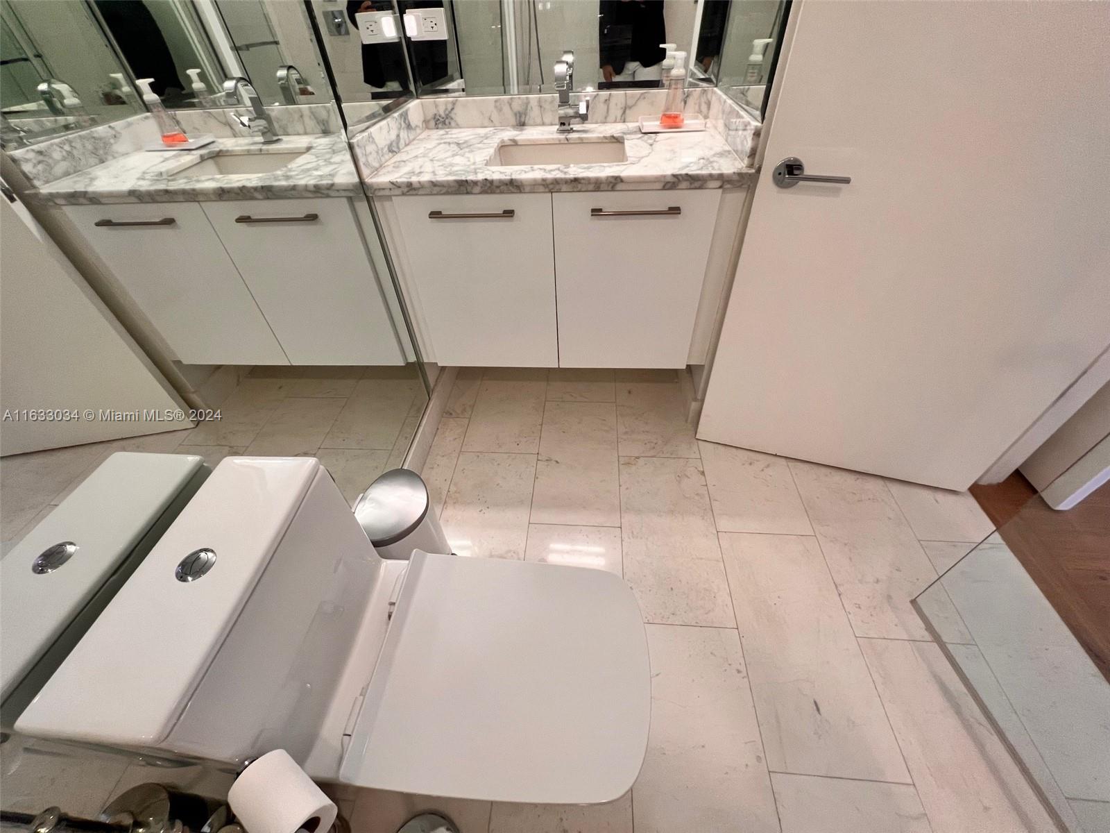 848 Brickell Key Drive, Unit 3701 Miami, FL 33131 - Photo 62 of 84 a bathroom with a sink and mirror