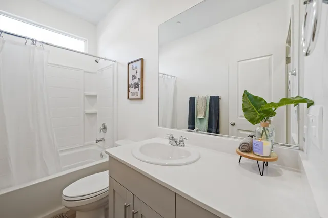 a bathroom with a sink toilet a mirror and shower