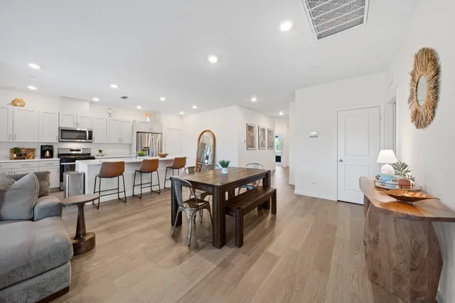 a living room with stainless steel appliances kitchen island a table and chair
