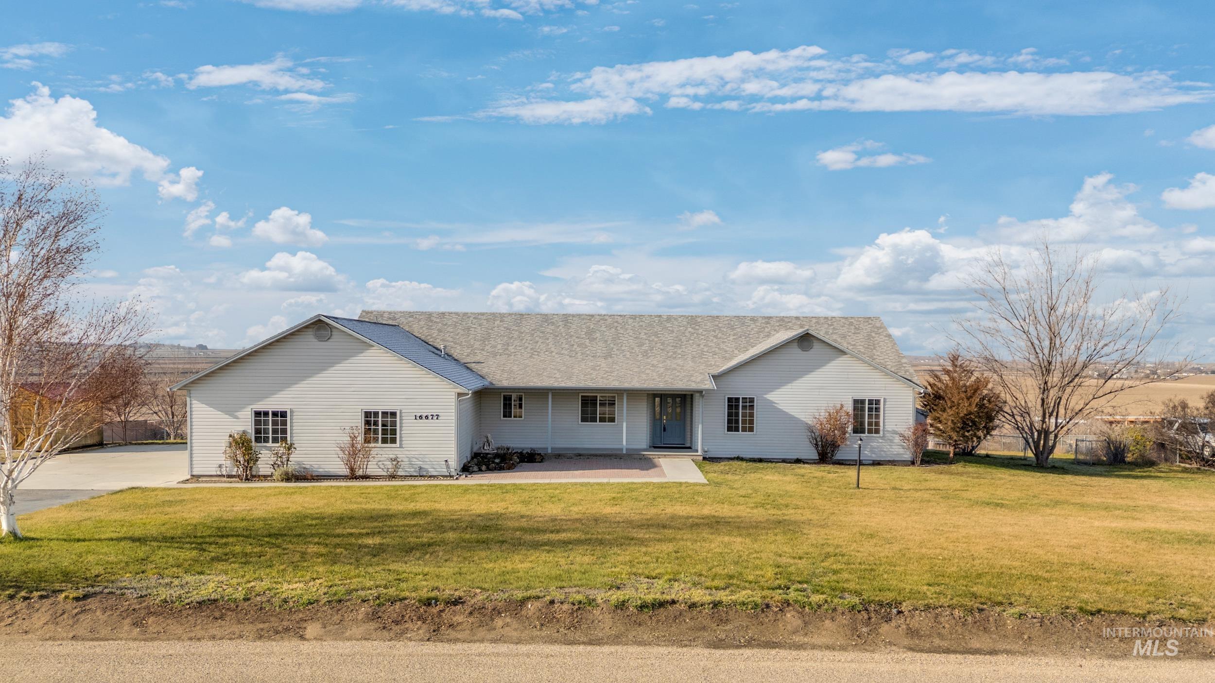 View of front of property with covered porch, a front lawn, and roof with shingles