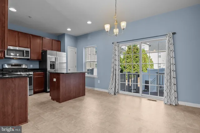 a kitchen with stainless steel appliances granite countertop a refrigerator and a stove top oven