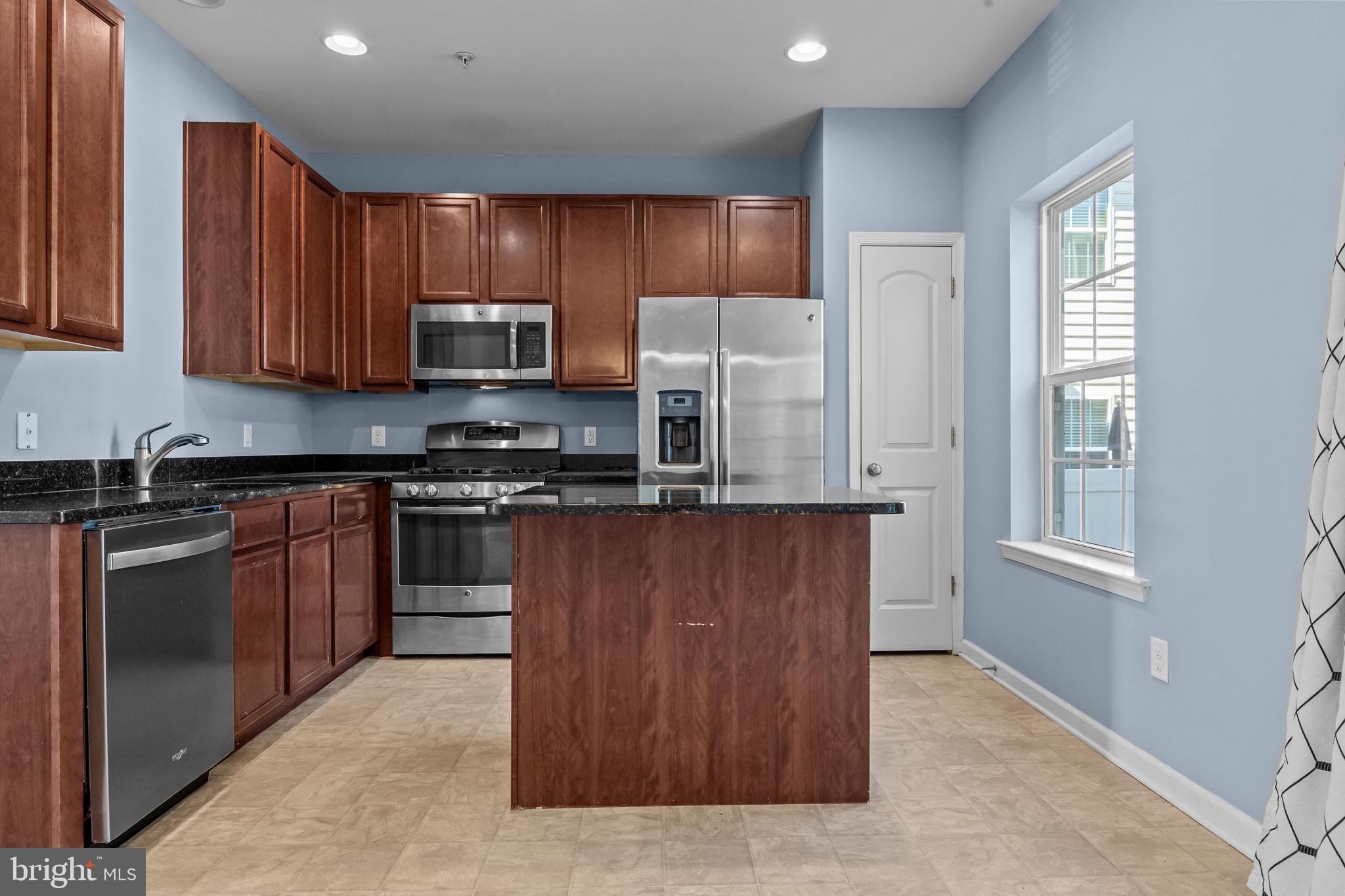 3753 Jacob Stout Road, Unit 3 Doylestown, PA 18902 - Photo 10 of 34 a kitchen with stainless steel appliances granite countertop a stove a sink dishwasher a refrigerator and a microwave oven with wooden cabinets