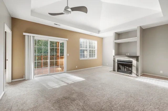a view of an empty room with a fireplace and a window