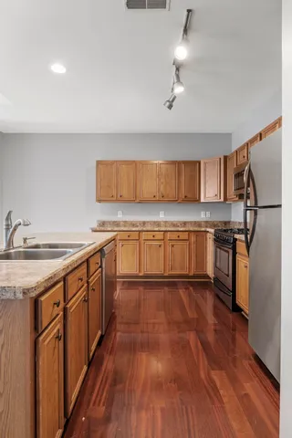 a kitchen with stainless steel appliances granite countertop a sink stove and refrigerator