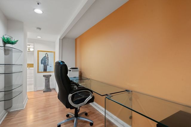a view of a workspace with furniture and wooden floor