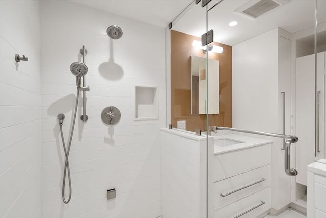 a bathroom with a granite countertop sink a toilet and shower