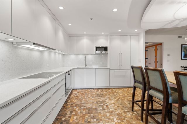 a large white kitchen with lots of counter space and appliances