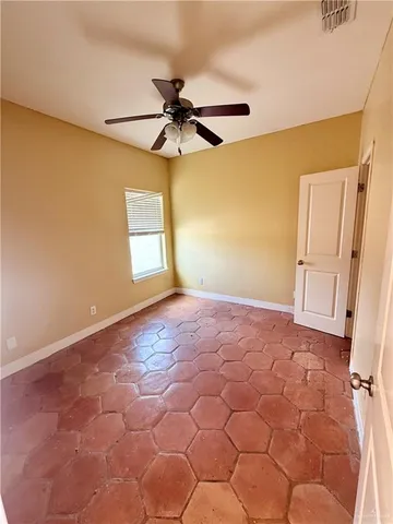 an empty room with windows and fan