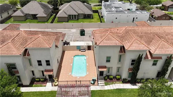 an aerial view of multiple houses with a yard