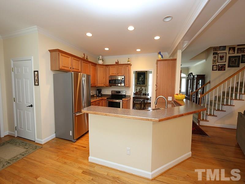 9009 New Century Road Wake Forest, NC 27587 - Photo 5 of 17 Kitchen opens to breakfast area and family room in the heart of the house. Includes stainless appliances, beautiful cabinets and bar area for extra seating.
