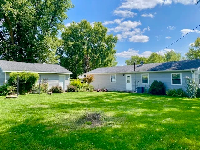 a backyard of a house with table and chairs