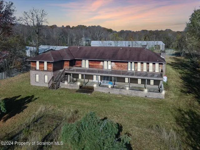 a view of a big house with a big yard and large trees