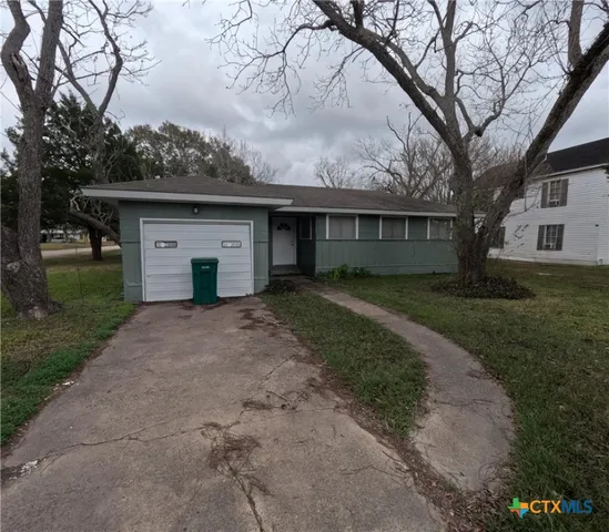a front view of house with yard and trees