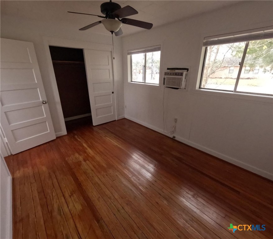 218 North 4th Ganado, TX 77962 - Photo 13 of 19 an empty room with wooden floor cabinet and windows