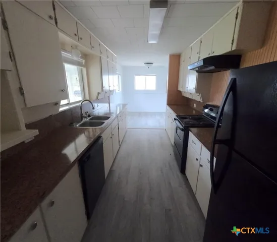 a kitchen with a sink stove and refrigerator