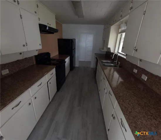 a kitchen with granite countertop sink stainless steel appliances and cabinets