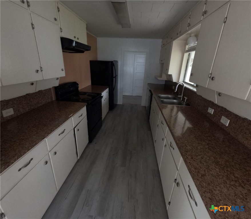 218 North 4th Ganado, TX 77962 - Photo 8 of 19 a kitchen with granite countertop sink stainless steel appliances and cabinets