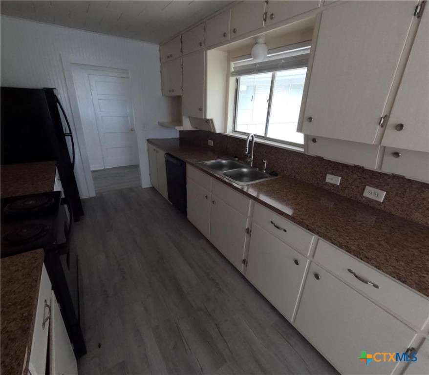 218 North 4th Ganado, TX 77962 - Photo 9 of 19 a kitchen with granite countertop a sink stove and refrigerator