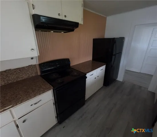 a kitchen with granite countertop cabinets and black appliances
