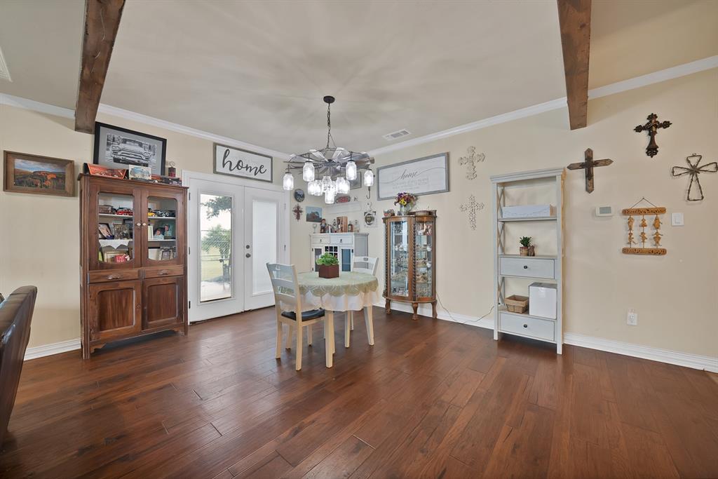 100 Shadle Ridge Court Poolville, TX 76487 - Photo 7 of 40 Expansive room featuring wood-finish flooring, exposed ceiling beams, and light-colored walls
