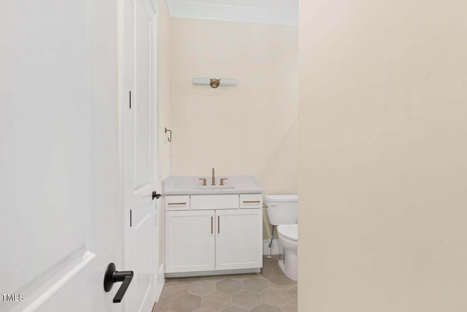 2410 Carpenter Pond Road Raleigh, NC 27613 - Photo 17 of 63 a bathroom with a granite countertop sink and a toilet
