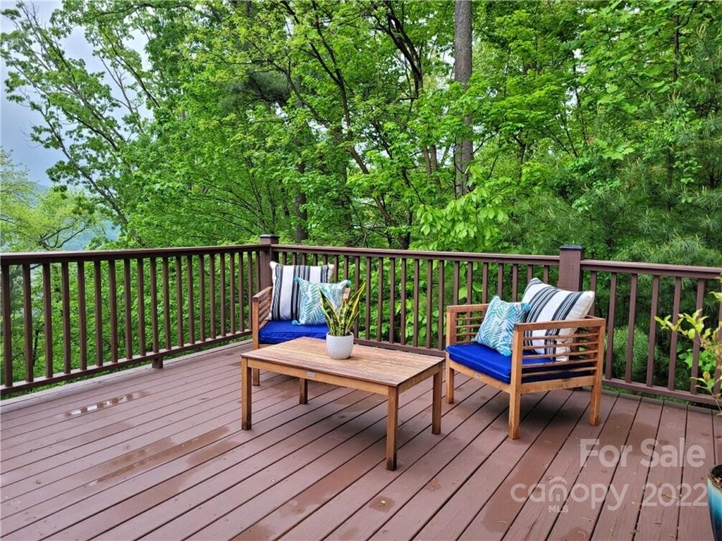 a deck with wooden floor table and chairs