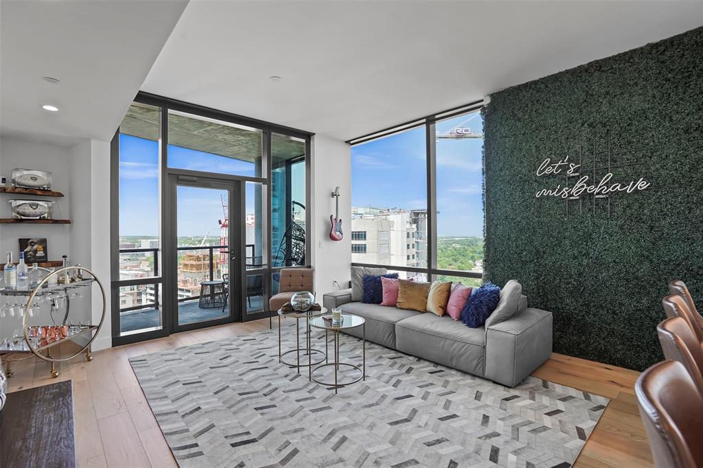 70 Rainey Street, Unit 1409 Austin, TX 78701 - Photo 2 of 38 Living room with light wood-type flooring, expansive windows, and an accent wall