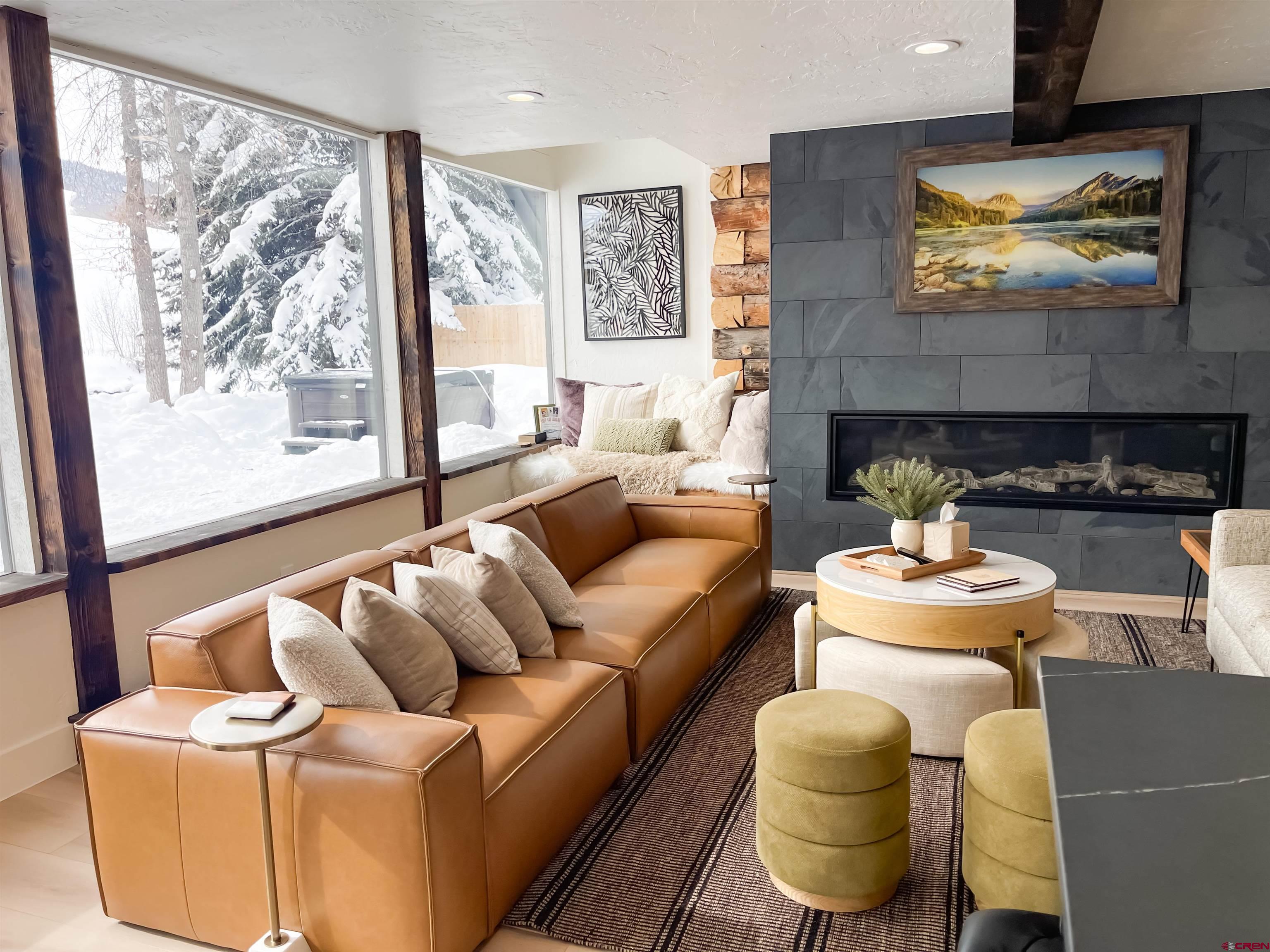 170 Lower Allen Road Crested Butte, CO 81224 - Photo 4 of 42 a living room with furniture a fireplace and a large window