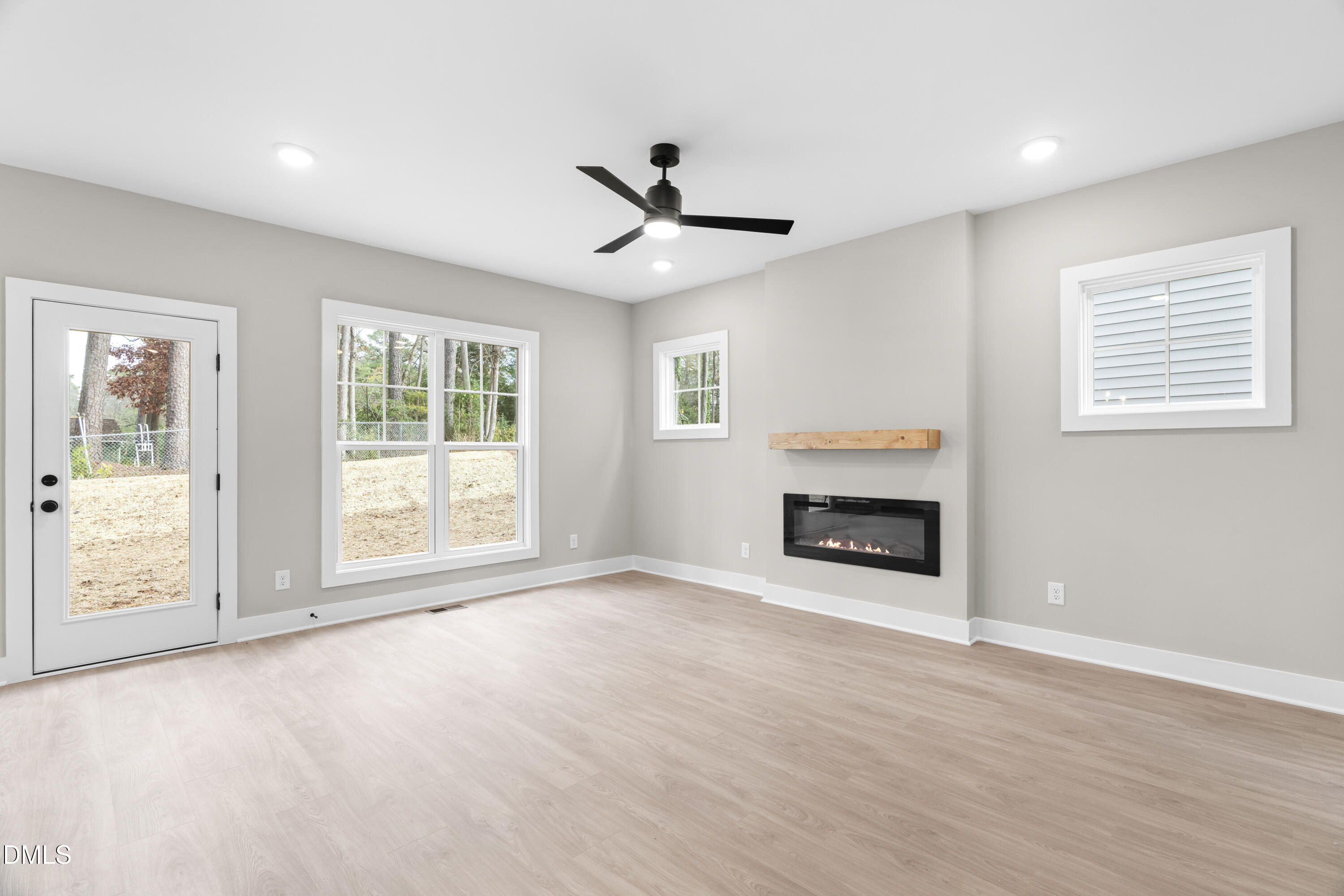 1016 Harper Road Raleigh, NC 27603 - Photo 11 of 46 wooden floor fireplace and windows in an empty room