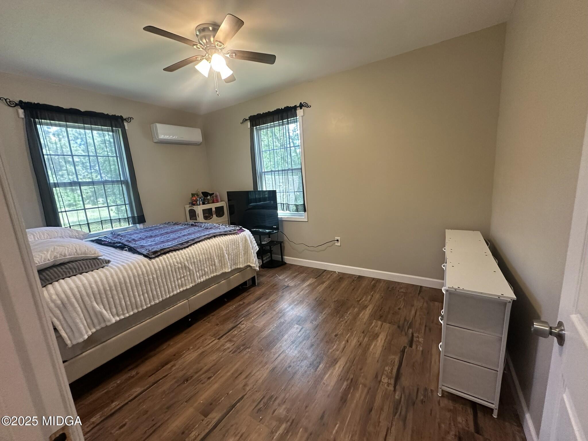 704 Tulip Drive Fort Valley, GA 31030 - Photo 9 of 13 a bedroom with a bed and wooden floor