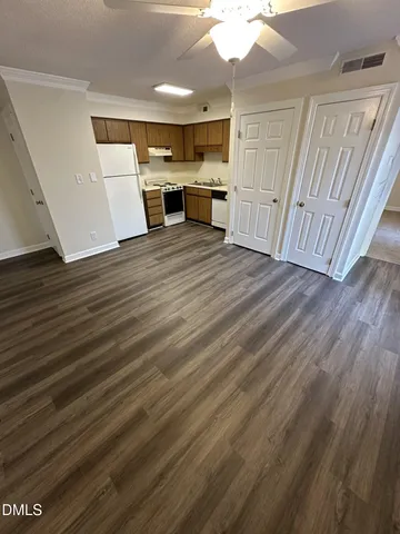 a kitchen with stainless steel appliances a refrigerator a sink a stove a microwave and wooden floors