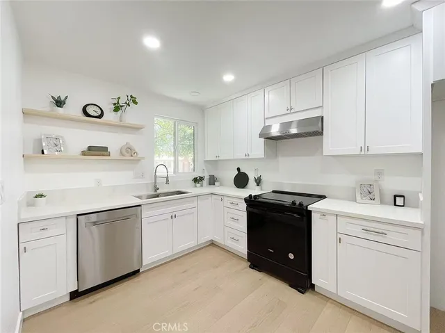 a kitchen with white cabinets and appliances
