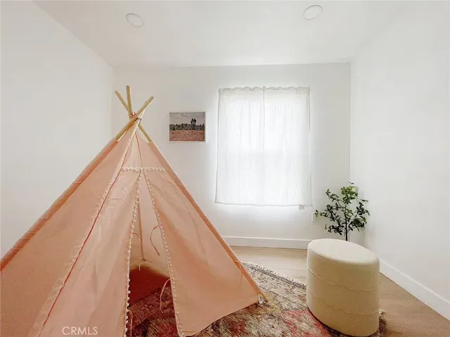 a living room with a bed and a potted plant