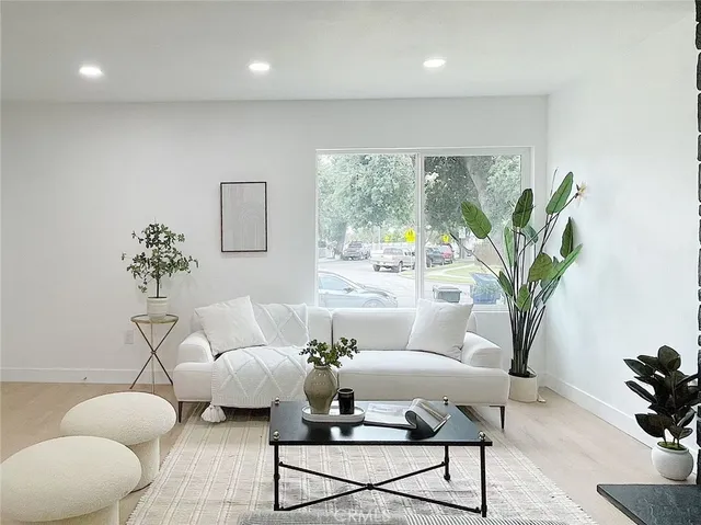 a living room with furniture potted plant and a large window