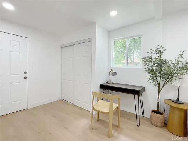 a view of a workspace room with furniture and window