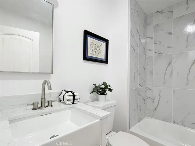 a bathroom with a sink mirror and toilet