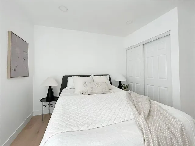 a bedroom with a bed and a lamp on the dresser